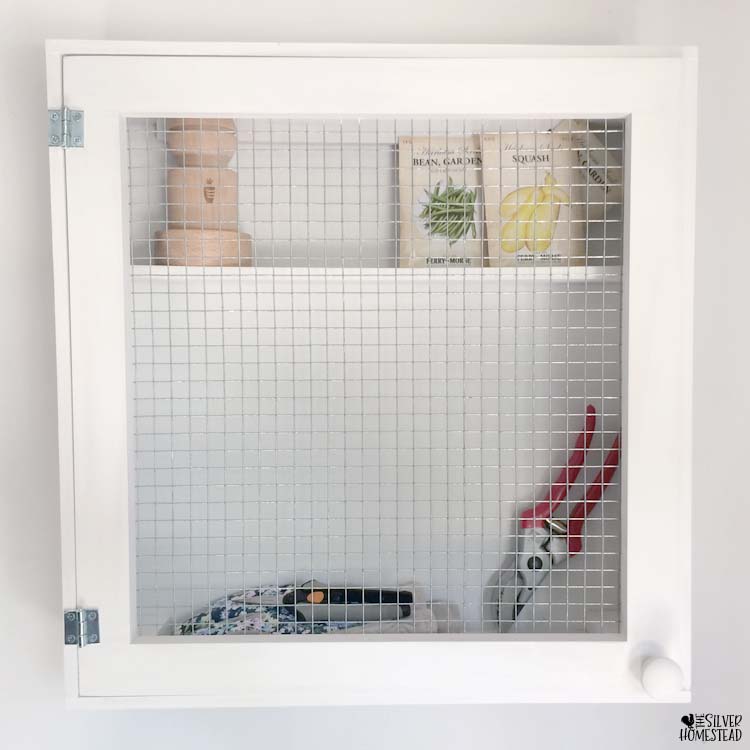 White chicken wire hardware cloth cabinet to organize garden tools