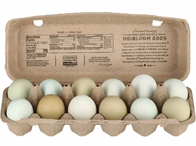 rainbow colored eating eggs in a carton at a grocery store with blue and green eggs